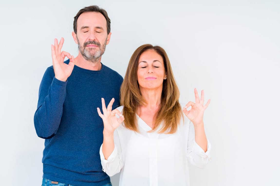 Couple faisant un geste de méditation pour symboliser la sérénité en matière de financement.