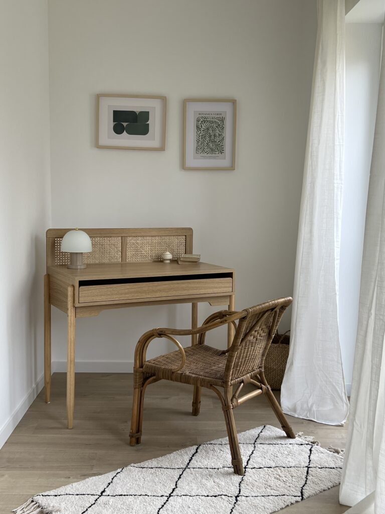 Coin bureau lumineux avec mobilier en bois et rotin près d’une fenêtre