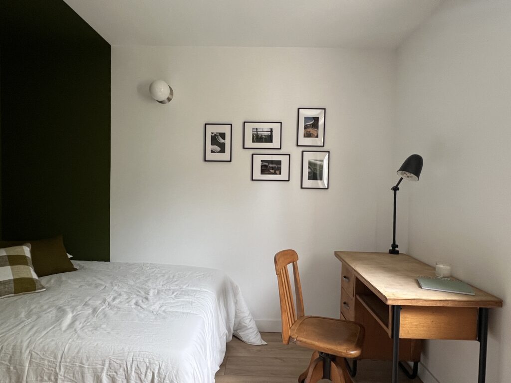 Chambre rénovée avec un bureau en bois et des décorations murales modernes.