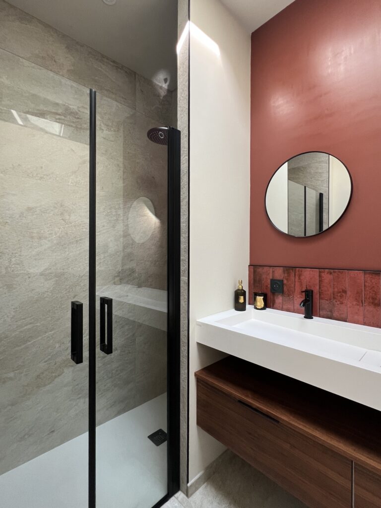 salle de bain rouge cerise effet mat avec carrelage blanc à fleurs noires