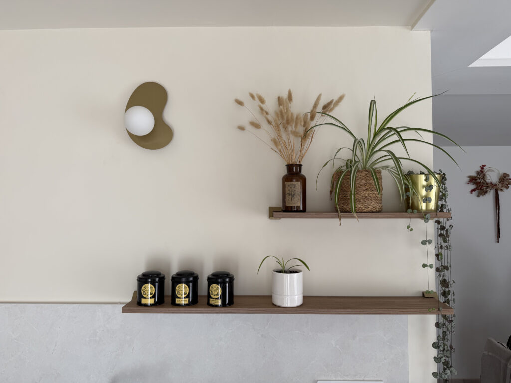 Étagères en bois avec plantes et décorations dans une cuisine moderne.