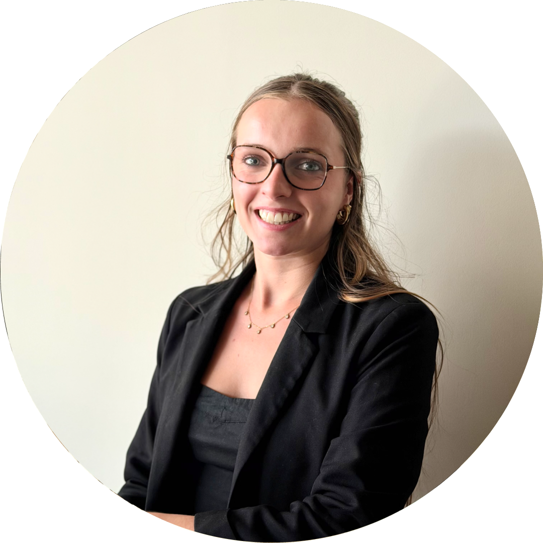 Zoé Gilles, architecte d'intérieur souriante au bureau, vêtue d'un blazer noir.